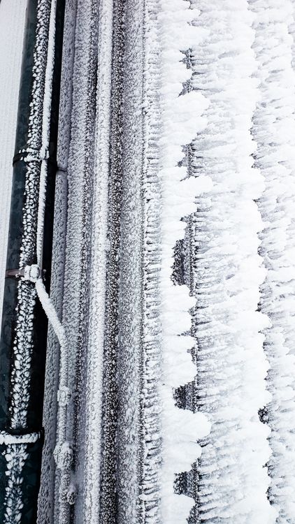 Frost-covered industrial pipes in cold weather