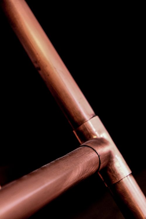 Close-up of copper pipes on dark background